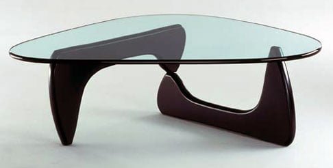 Mid century modern coffee table aesthetic by Noguchi, the Japanese American sculptor and furniture designer. The image shows a glass tables on to two furniture stands amplifying the designers work.